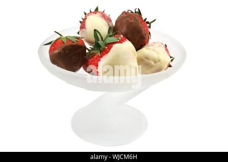 L'été frais fraises UK trempé dans le chocolat au lait et blanc dans une assiette à dessert en verre dépoli Banque D'Images