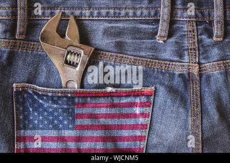 Clé à molette dans la poche arrière d'un jean bleu avec USA flag. USA concept fête du Travail heureux. Banque D'Images
