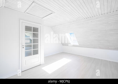 Cette chambre lumineuse avec le soleil qui brille à travers une petite fenêtre dans un appartement en bois avec une porte en verre Banque D'Images