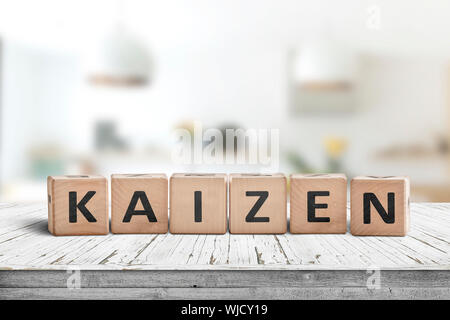 Amélioration Kaizen signe fait de blocs sur un bureau en bois dans une salle lumineuse Banque D'Images