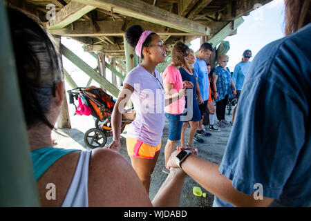 Groupe de l'Église prient pour un ouragan de manquer l'Isle of Palms, L.C. (Le groupe est de prier dans le cadre de l'embarcadère de l'île de Palms. Banque D'Images