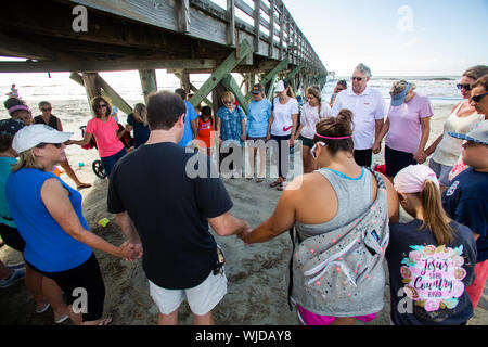 Groupe de l'Église prient pour un ouragan de manquer l'Isle of Palms, L.C. (Le groupe est de prier dans le cadre de l'embarcadère de l'île de Palms. Banque D'Images