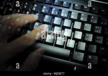 Clavier dans la nuit noire avec la main et des doigts montrant concept internet Banque D'Images