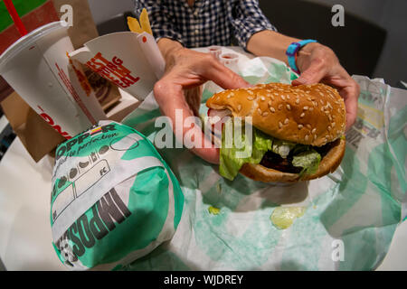 Une salle à manger bénéficie d''un Burger King Whopper impossible, un sandwich sans viande de boeuf au sol, dans un restaurant Burger King à New York le Mardi, Août 27, 2019. Le nouvel élément de menu utilise 1/4 livre de cuisine à base de plantes par Impossible les aliments. (© Richard B. Levine) Banque D'Images