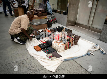 Un vendeur met en place boutique vendant des sacs à main Knock-off sur la Cinquième Avenue à New York, le samedi, 31 août, 2019. (© Richard B. Levine) Banque D'Images