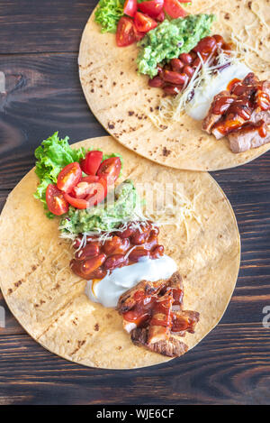 Les tacos avec des remplissages sur la table en bois Banque D'Images