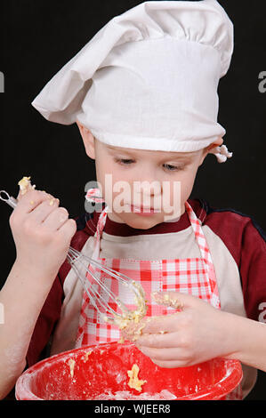 Boy in chef hat pétrir la pâte Banque D'Images