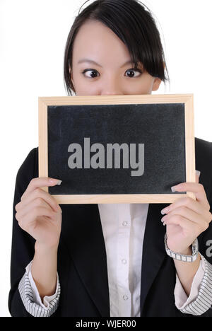 Young business girl holding blackboard et montrant expression drole sur fond blanc. Banque D'Images