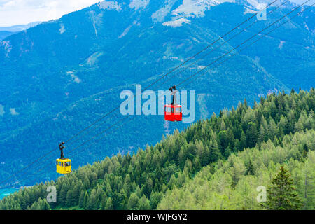 Avis de rouge et jaune téléphérique Seilbahn gondoles contre montagnes dans la région de Salzkammergut Zwolferhorn mountain à St.Gilgen, Autriche Banque D'Images