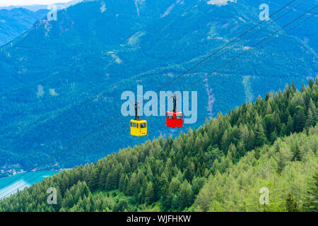 Avis de rouge et jaune téléphérique Seilbahn gondoles contre montagnes dans la région de Salzkammergut Zwolferhorn mountain à St.Gilgen, Autriche Banque D'Images