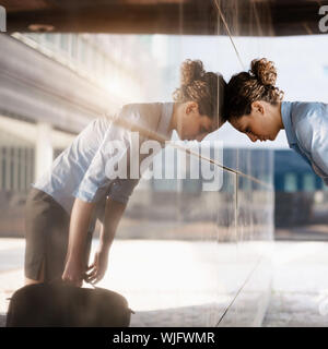 Mid adult femme italienne claque sa tête contre un mur à l'extérieur de bâtiment de bureaux. Forme carrée, copy space Banque D'Images