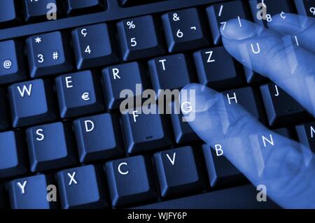 Clavier dans la nuit noire avec la main et des doigts montrant concept internet Banque D'Images