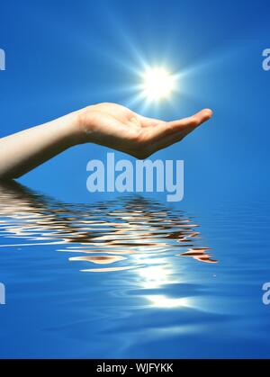 Main tenant le soleil et l'eau reflaction avec copyspace Banque D'Images