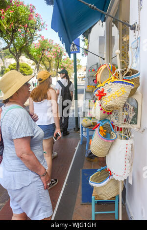 Île de Capri, ITALIE - AOÛT 2019 : personne parcourt sur les marchandises exposées à l'extérieur d'une boutique dans la ville de Capri. Banque D'Images