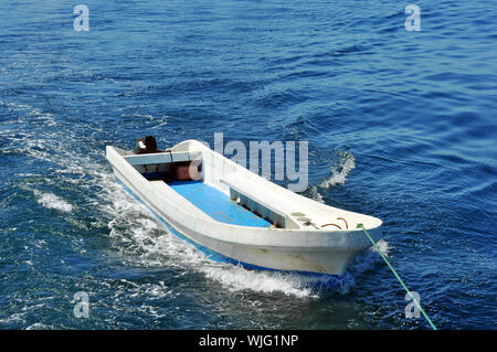 Petit bateau remorqué sur la mer tropical bleu Banque D'Images