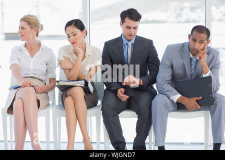 Quatre personnes en attente d'entrevue d'emploi dans un bureau lumineux Banque D'Images