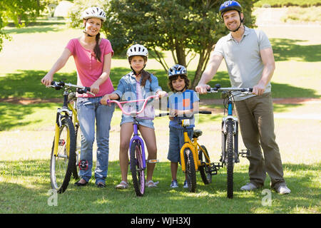 Portrait d'une famille de quatre personnes avec des vélos dans le parc Banque D'Images