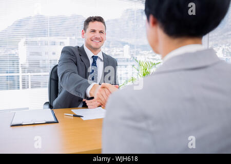 Smartly dressed shaking hands après une réunion d'affaires dans le bureau Banque D'Images