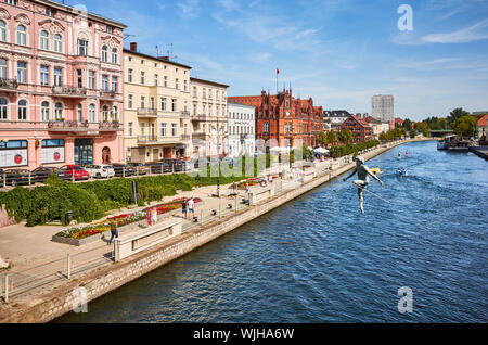 Bydgoszcz, Pologne - 25 août 2019 : Bydgoszcz cityscape vu depuis un pont avec funambule sculpture sur rivière Brda. Banque D'Images