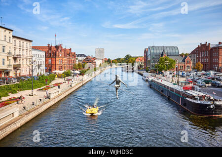 Bydgoszcz, Pologne - 25 août 2019 : Bydgoszcz cityscape vu depuis un pont avec funambule sculpture sur rivière Brda. Banque D'Images