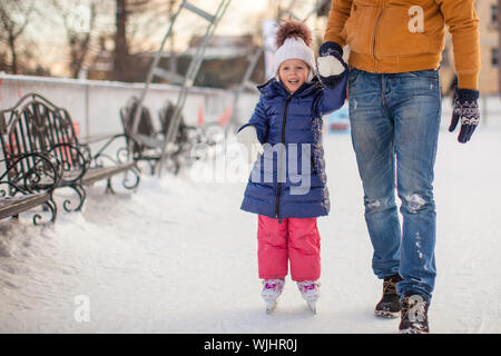 Jeune père de l'enseignement sa petite fille à patiner sur la patinoire Banque D'Images