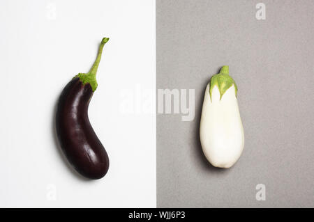 Sombre et aubergines blanches isolé sur fond duotone. Concept de différence. Banque D'Images