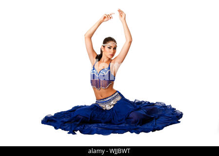 Belle égyptienne Israélien moyen-orientale danseuse du ventre libanaise performer en bleu jupe et soutien-gorge avec des bras dans l'air assis, isolé. Banque D'Images