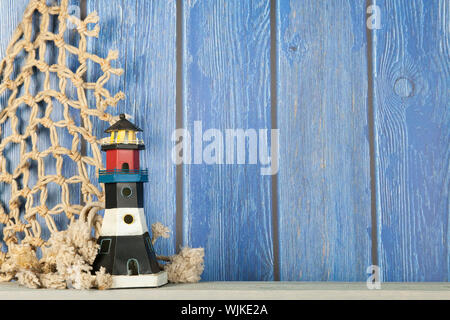 Scène de plage avec phare et filet de pêche sur fond bleu colombages Banque D'Images