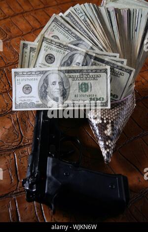 Notes et Dollar, des armes à feu plus crocodrile pistolet noir Cuir noir faux Banque D'Images