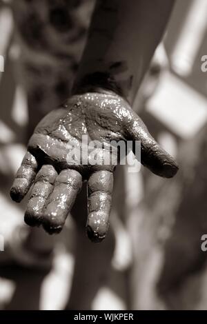 Les enfants, les mains sombres sale jeu de peinture, de boue, de graisse, noir et blanc Banque D'Images