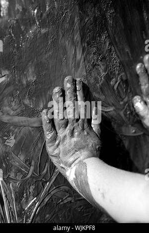 Les enfants, les mains sombres sale jeu de peinture, de boue, de graisse, noir et blanc Banque D'Images