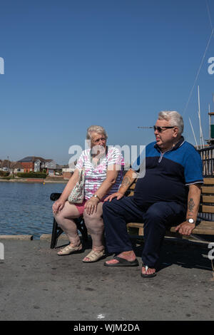 Un excès de couple assis sur un banc de parc Banque D'Images