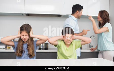 Les jeunes enfants pendant que les parents triste de se quereller dans la cuisine à la maison Banque D'Images