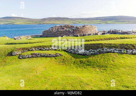 Broch de Gurness flanquée de digues de terre renforcée par la pierre. Les ruines du village broch l'entourent. Banque D'Images