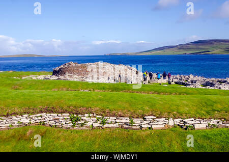 Broch de Gurness flanquée de digues de terre renforcée par la pierre. Les ruines du village broch l'entourent. Banque D'Images