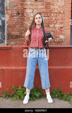 Hipster femme photographe avec appareil photo sur film retro old brick wall Banque D'Images