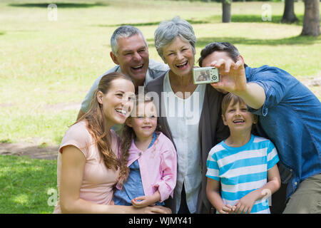 Man taking picture de son cheerful extended family at the park Banque D'Images