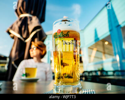 Overveen, Pays-Bas, - Aug 23, 2019 : la bière Grolsch à Parnassia Cafe avec femme en arrière-plan - est le néerlandais Grolsch brewery fondée en 1615 par Willem Neerfeldt à Groenlo Banque D'Images