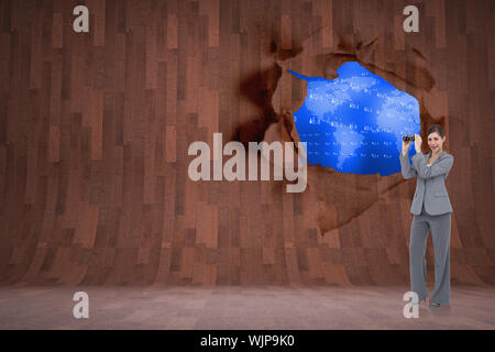 Businesswoman posing with binoculars contre rip sur mur montrant la carte bleue Banque D'Images