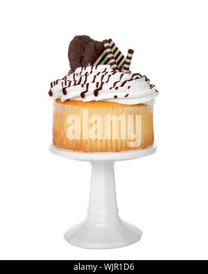 Vanille cup cake géant avec glaçage blanc, chocolat bonbons et chocolat cookies embellir assis sur un piédestal blanc isolé sur blanc. Banque D'Images