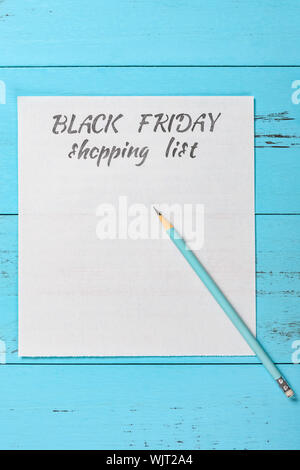 Vue d'en haut la main vendredi noir liste d'achats à l'aide d'un crayon Banque D'Images