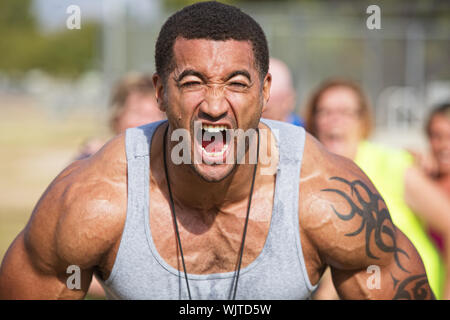 Instructeur de conditionnement physique musculaire hurlant flexing muscles Banque D'Images