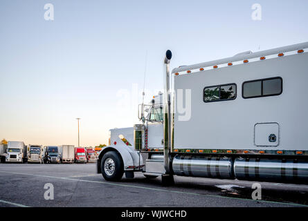 Big Rig classic American Idol white industrial grade semi truck avec chrome tuyaux et réservoirs de carburant ajouté dans le transport du fret sur semi-remorque Banque D'Images