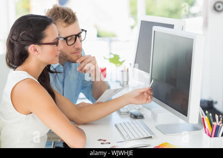 Partenaires créatifs travaillant sur ordinateur à leur bureau en bureau de création Banque D'Images