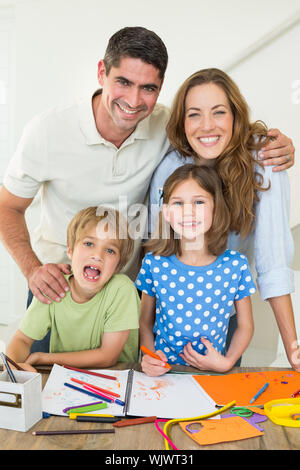 Portrait of happy parents avec enfants table à dessin Banque D'Images