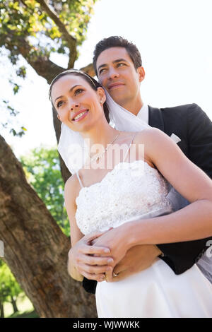 Low angle view of newly wed couple standing in garden Banque D'Images