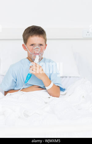 Portrait d'un petit garçon sur le lit avec un masque à oxygène à l'hôpital Banque D'Images