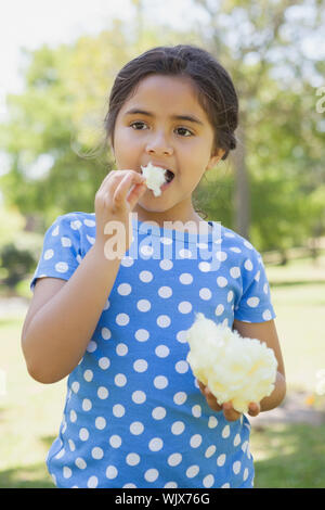 Portrait d'une belle little girl eating Cotton Candy at the park Banque D'Images