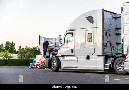 Bonnet blanc gros camion semi truck avec capot moteur ouvert pour inspection et réparation mobile possible debout sur le truck stop parking sur ligne avec ano Banque D'Images