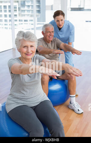 Female therapist aider senior couple avec des exercices dans le bureau médical Banque D'Images